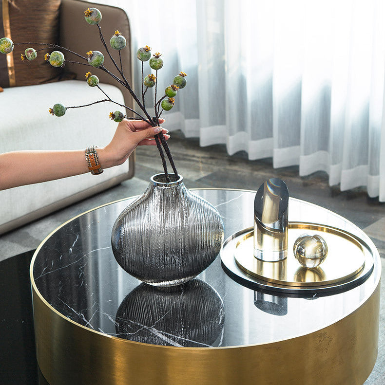 Round coffee table with decorative items in a living room setting