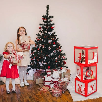 Two children holding presents in front of a decorated Christmas tree with a red and white decorative boxes.