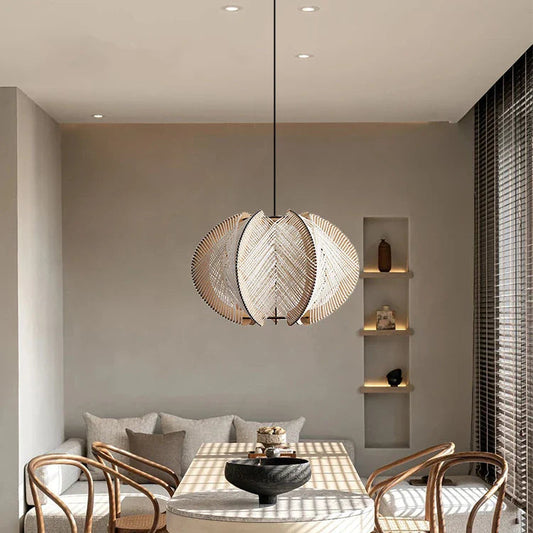 Modern dining room with marble table, wooden chairs, and pendant light.