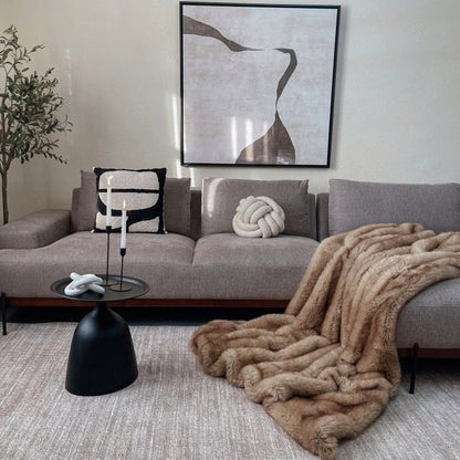 Living room with a gray sofa, decorative pillows, and a fur throw blanket.